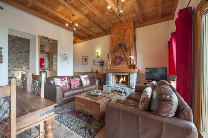 The living area is complete with comfortable leather sofas and cosy log fire.