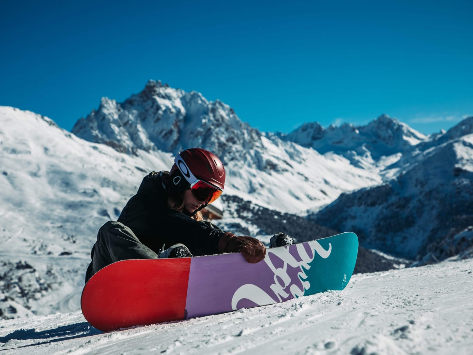 Snowboarder sitting on piste