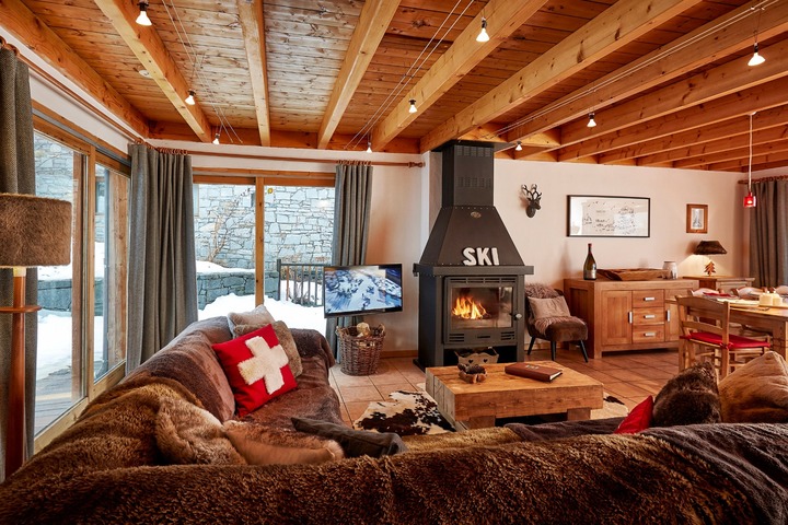 Chalet C'est la Vie has an inviting interior, with exposed wooden beams, warm furnishings and log fire.
